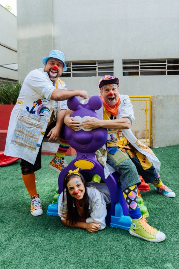 Os três palhaços do Soul Alegria posando abraçados em um parquinho